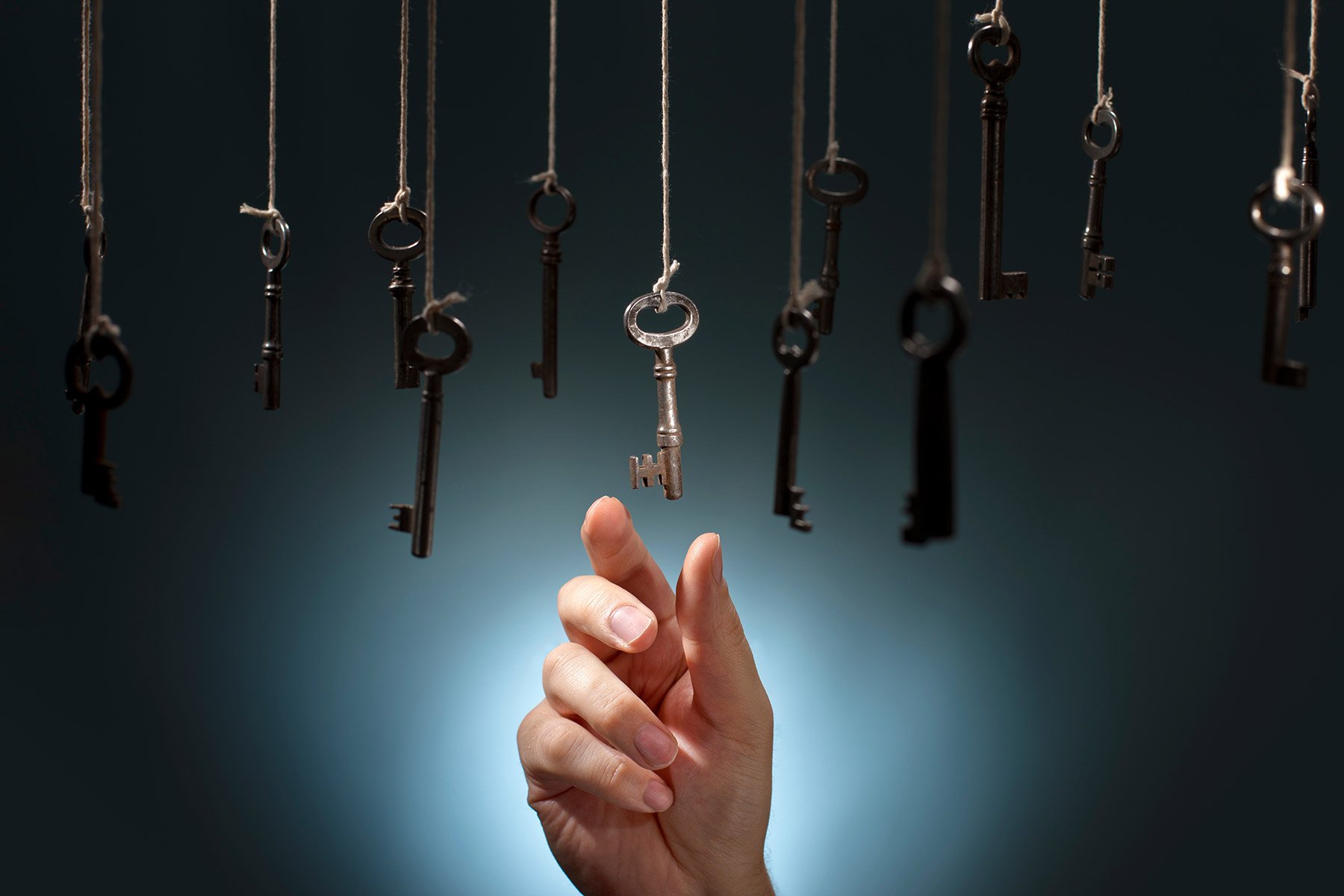 Symboldbild: Hand wählt einen von herunterhängenden Schlüssen aus –&nbsp;als Visualisierung für die Auswahl einer HubSpot-Agentur