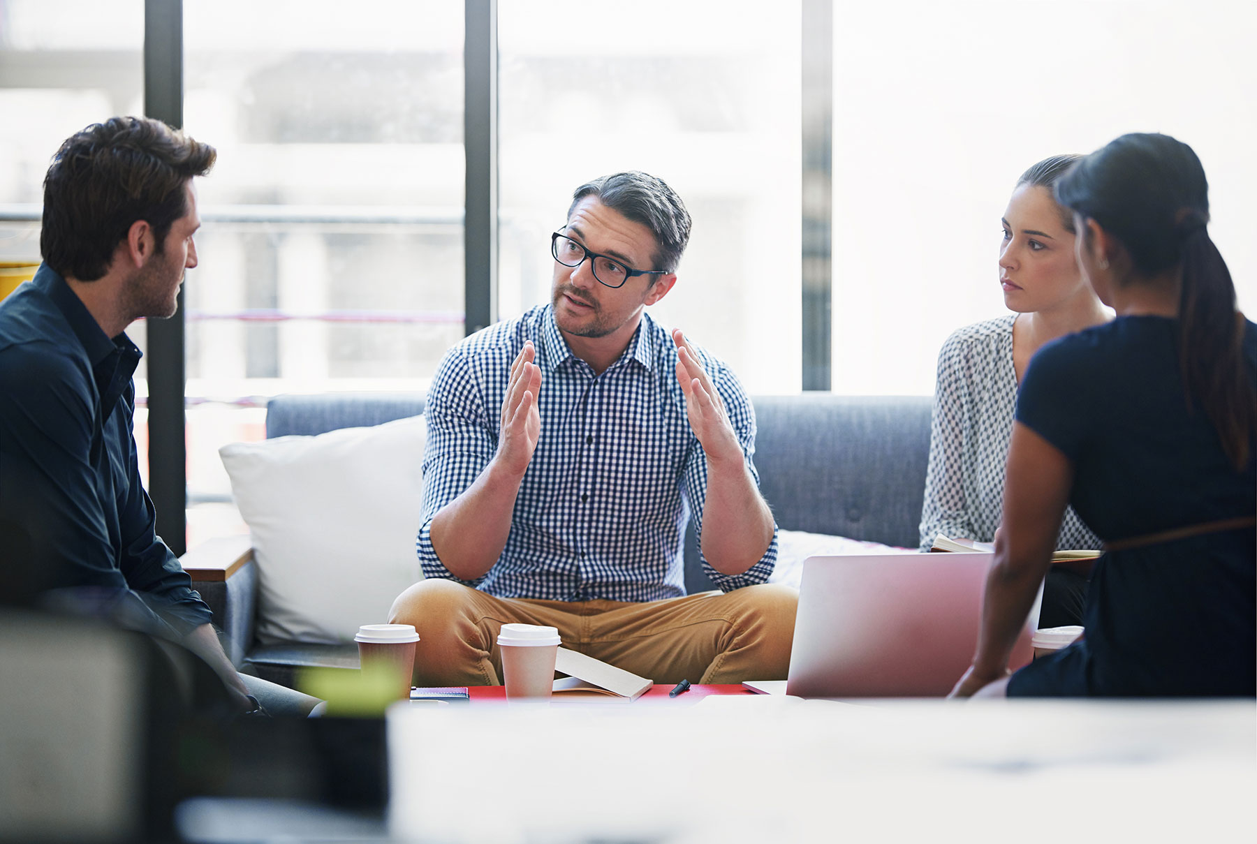 Business-Meeting mit Firmeninhaber und drei weiteren Personen, bei denen die Einführung von HubSpot besprochen wird.
