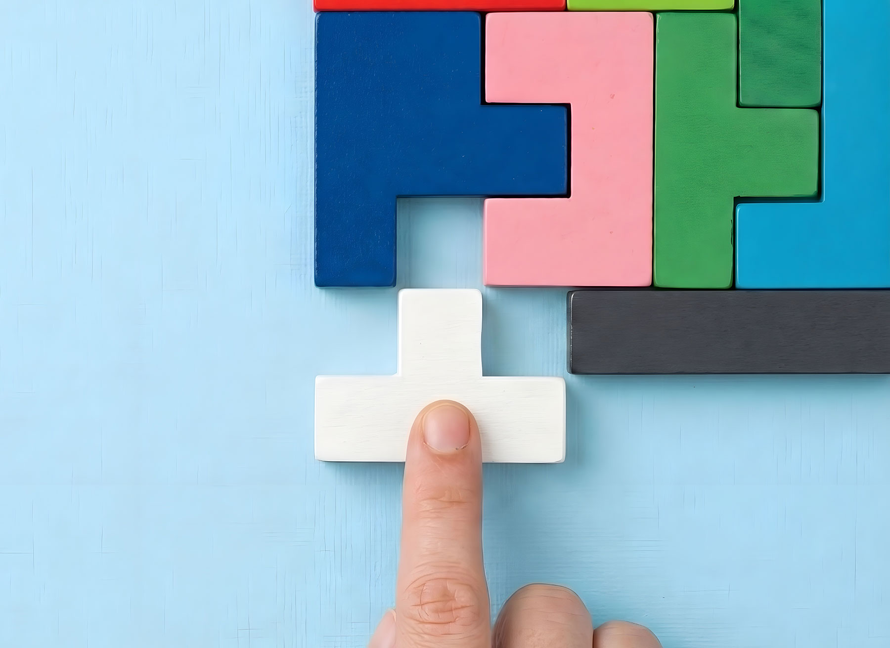 Symbolbild für passenden HubSpot-Partner finden: Finder schieb passenden Block in Lücke in einer tetrisartig anmutenden Ansammlung von Klötzchen